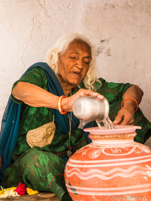 Alte Frau beim Chai Tee kochen